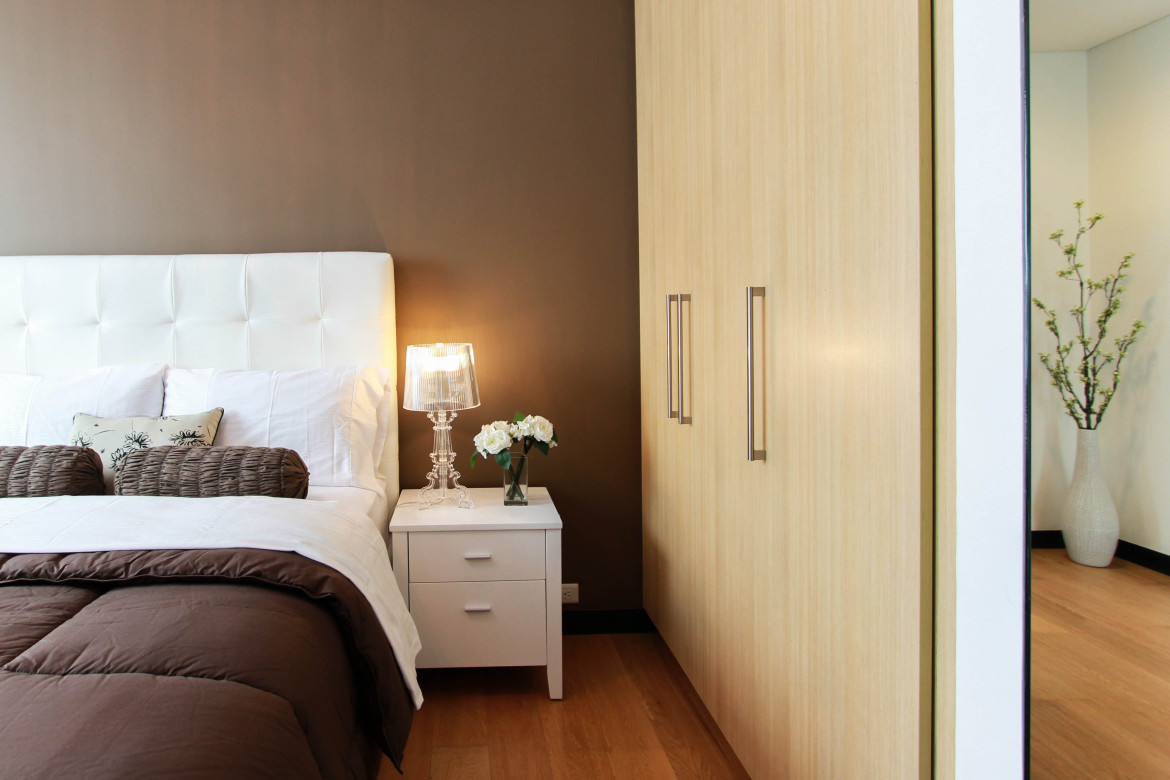 white-bed-next-to-white-accent-table-90319